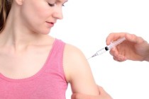 Bild: junge Frau mit rosafarbenem Top erhält eine Impfung